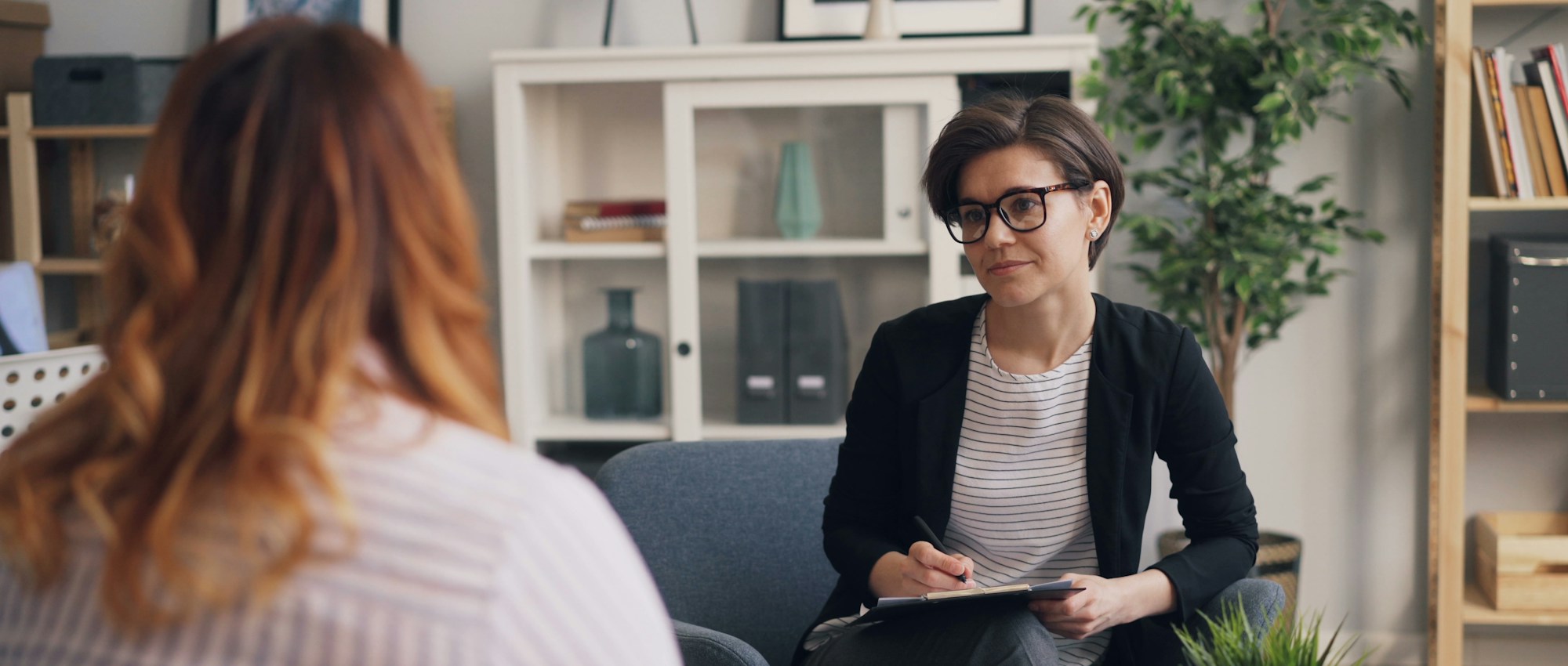 Professional taking notes during a calm one-on-one conversation